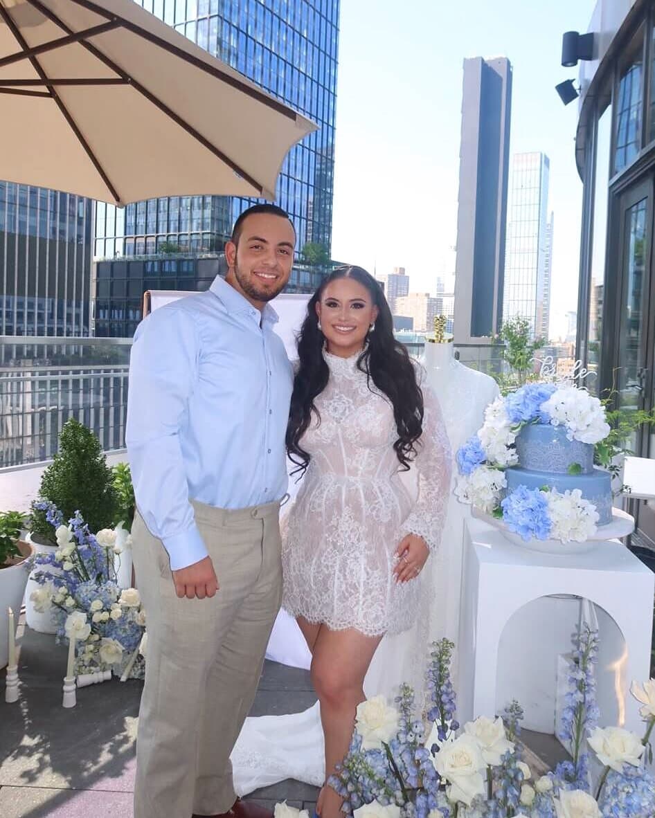 A couple at a rooftop celebration surrounded by blue-and-white florals